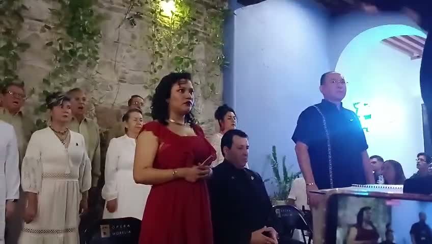 Natali Juárez canta una aria con el coro al fondo